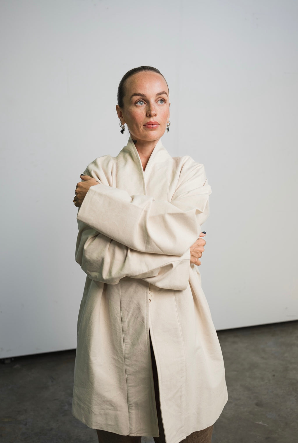 Unisex painter’s coat in unbleached raw cotton canvas with bone button and practical pockets