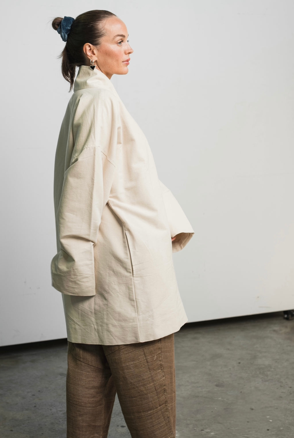 Unisex painter’s coat in unbleached raw cotton canvas with bone button and practical pockets