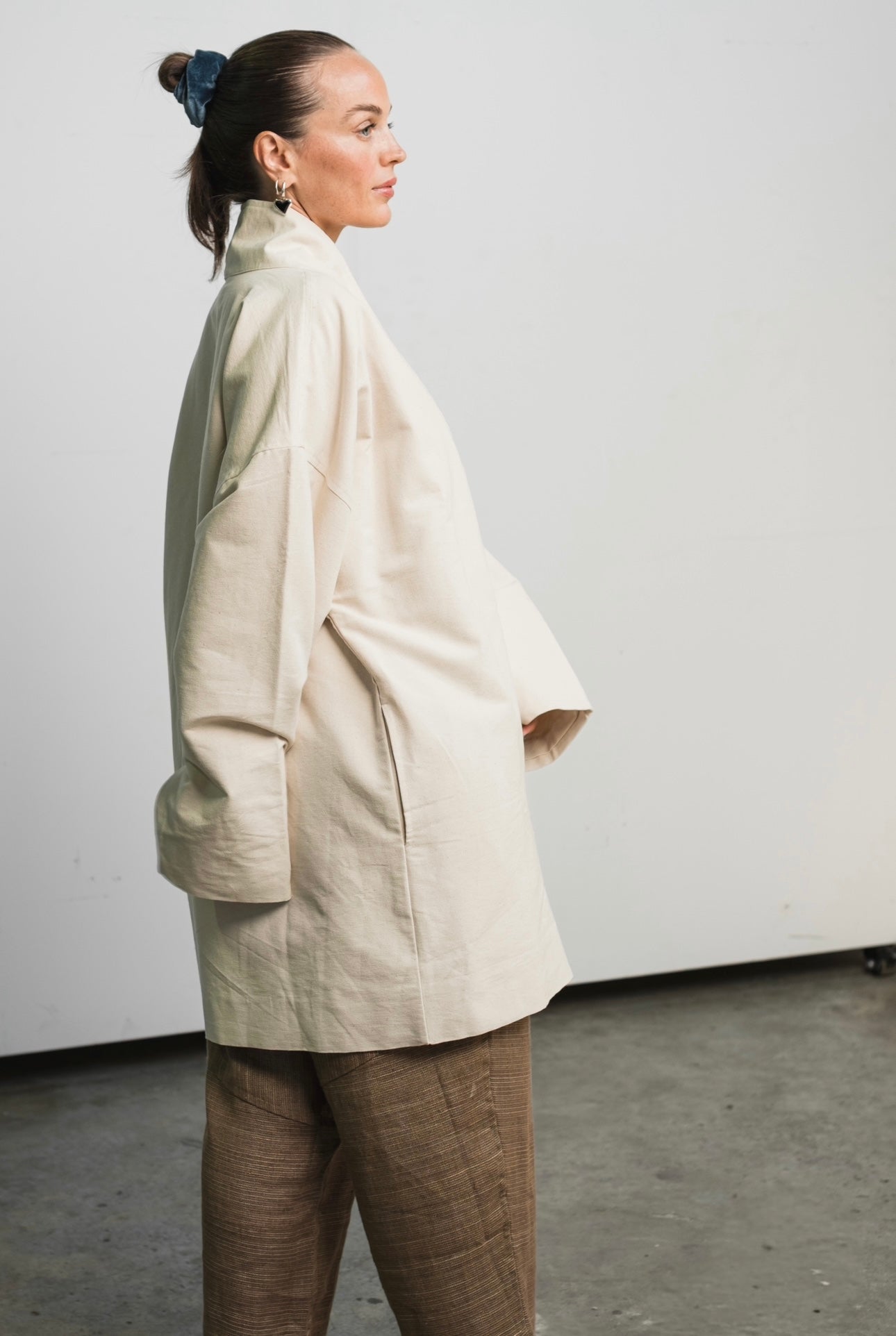 Unisex painter’s coat in unbleached raw cotton canvas with bone button and practical pockets