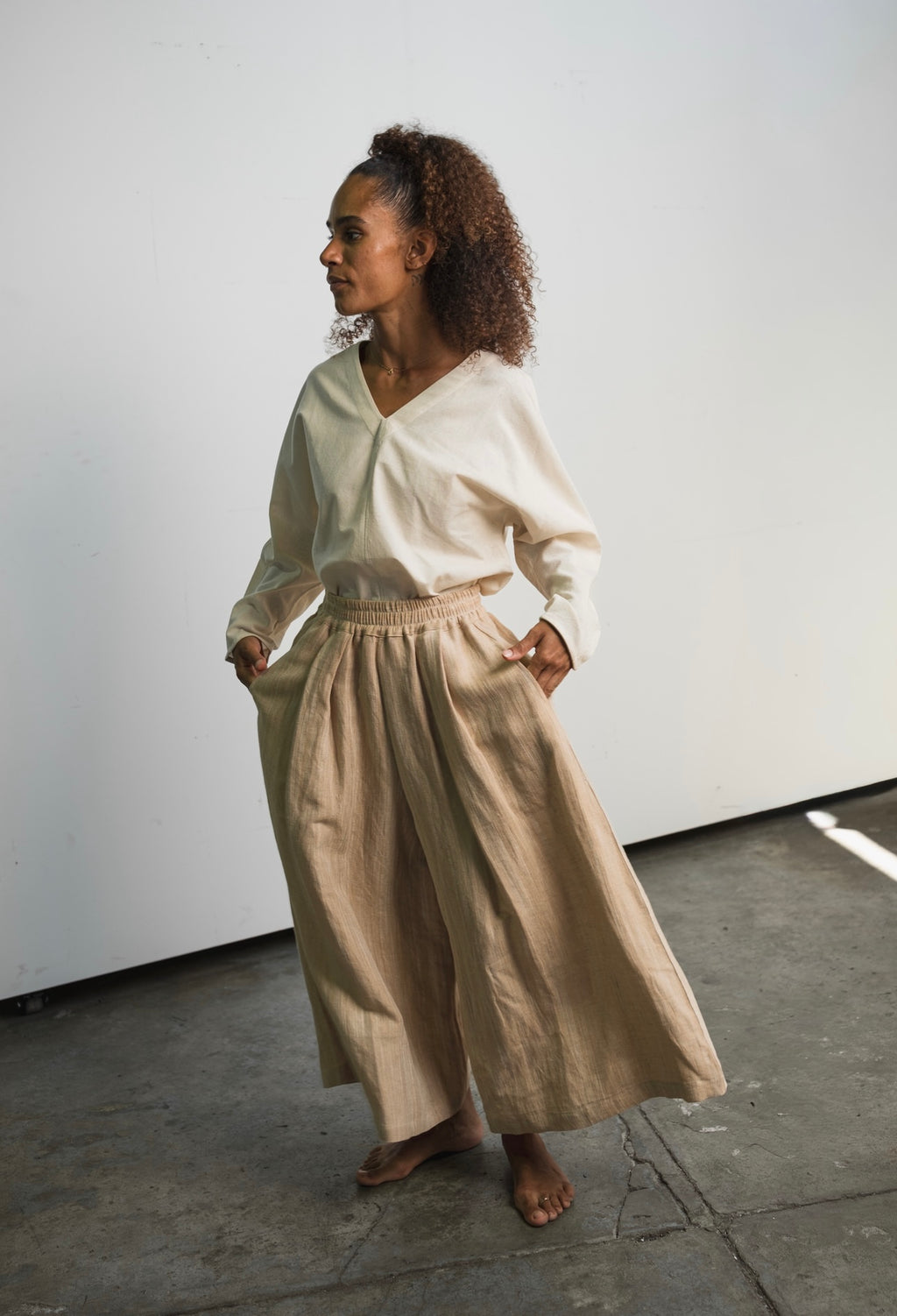 Kora cotton long sleeve top with V-neck design and tapered fit
