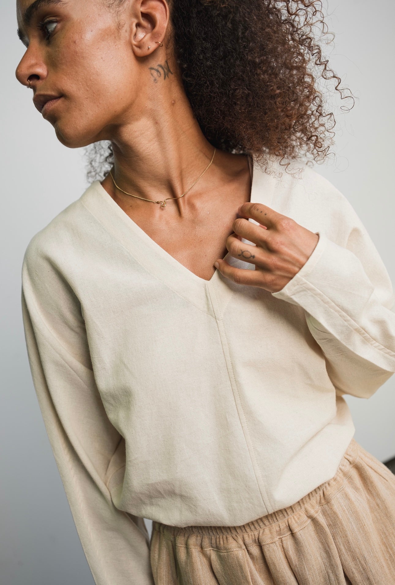 Kora cotton long sleeve top with V-neck design and tapered fit
