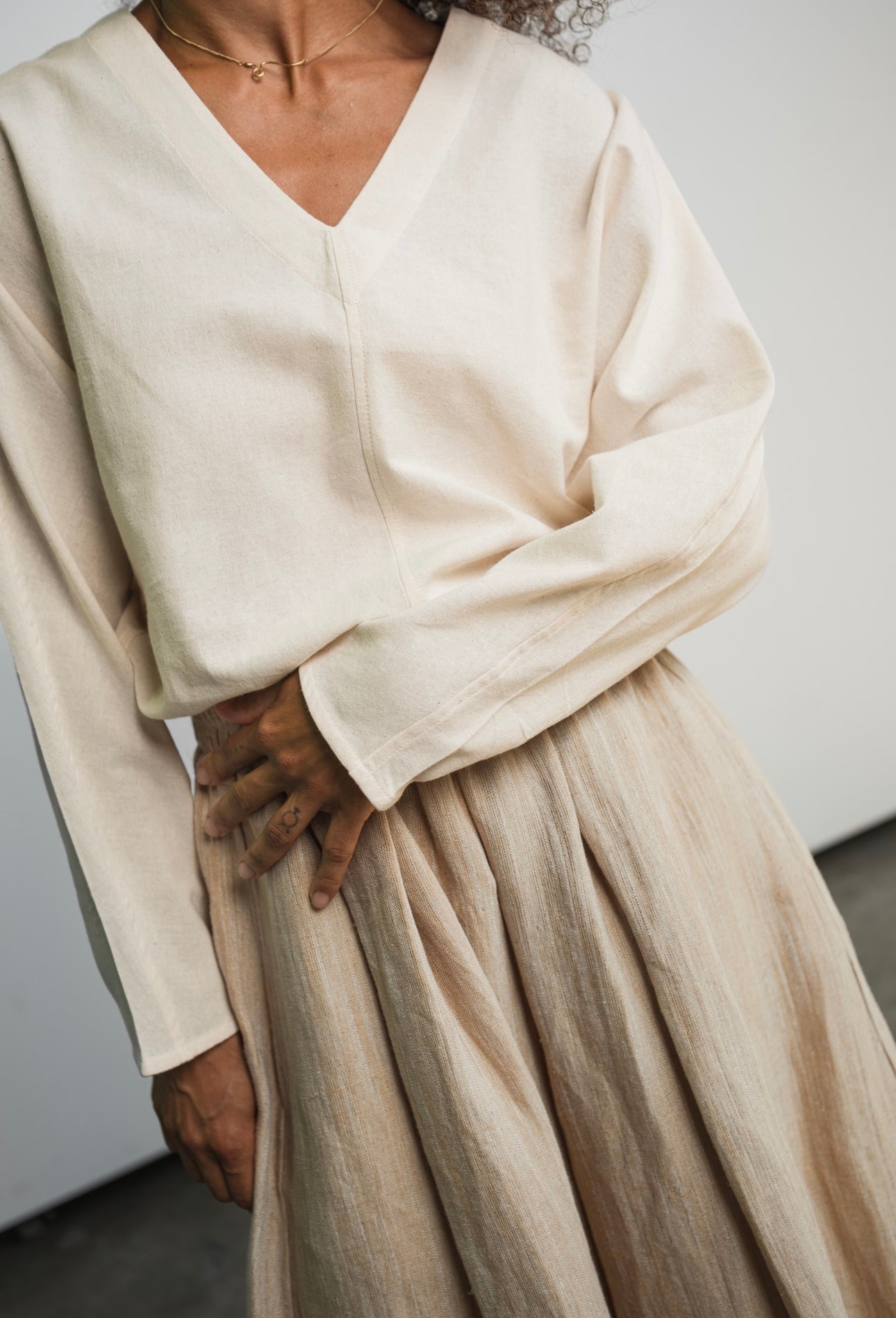 Kora cotton long sleeve top with V-neck design and tapered fit
