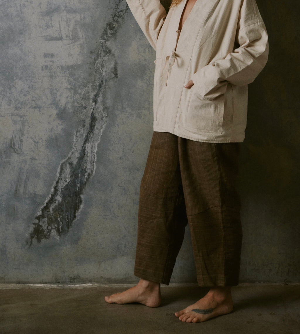 Lightweight linen trousers with elastic waistband, abstract hem detail, and unisex fit
