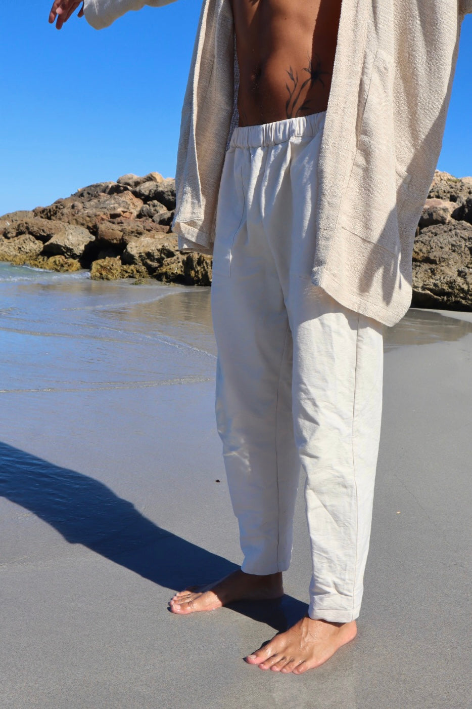 Unisex straight-leg garment in raw unbleached cotton canvas with front pockets
